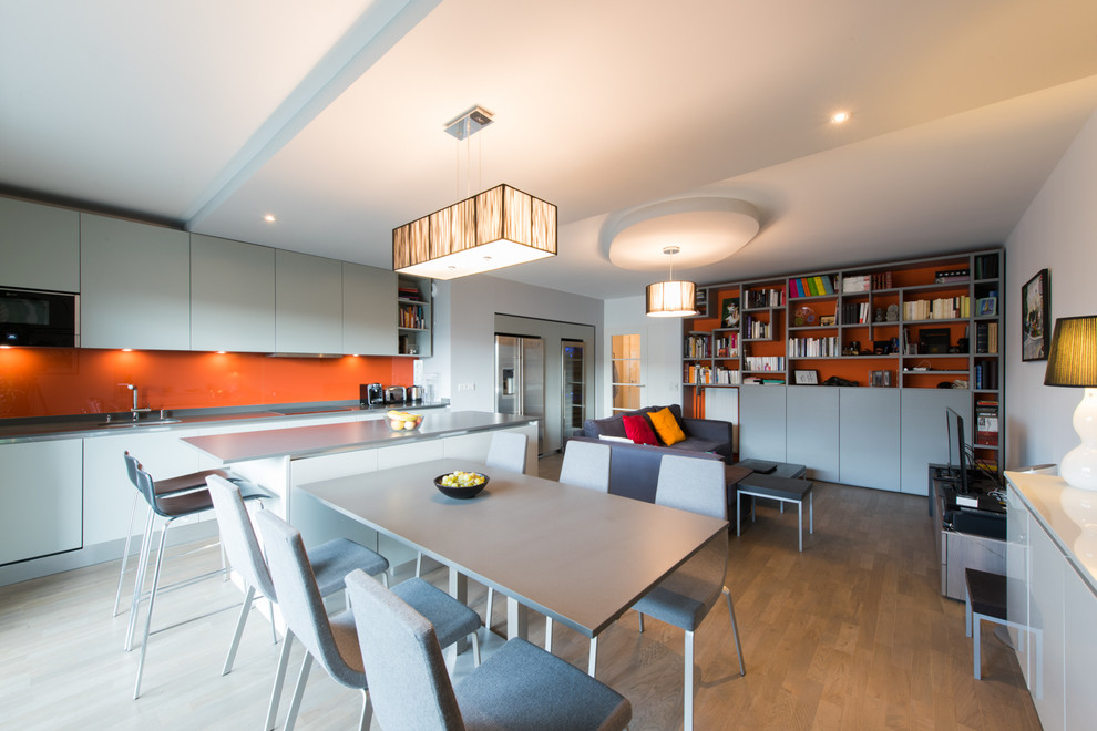 Inspiration pour une salle à manger ouverte sur le salon design de taille moyenne avec un mur blanc, parquet clair et aucune cheminée.