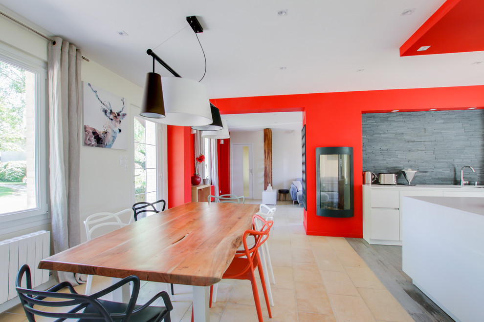 ランスにある高級な広いコンテンポラリースタイルのおしゃれなダイニングキッチン (赤い壁、薪ストーブ、ベージュの床) の写真