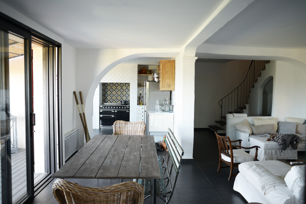 Cette image montre une salle à manger ouverte sur le salon méditerranéenne de taille moyenne avec un mur blanc et un sol en carrelage de céramique.