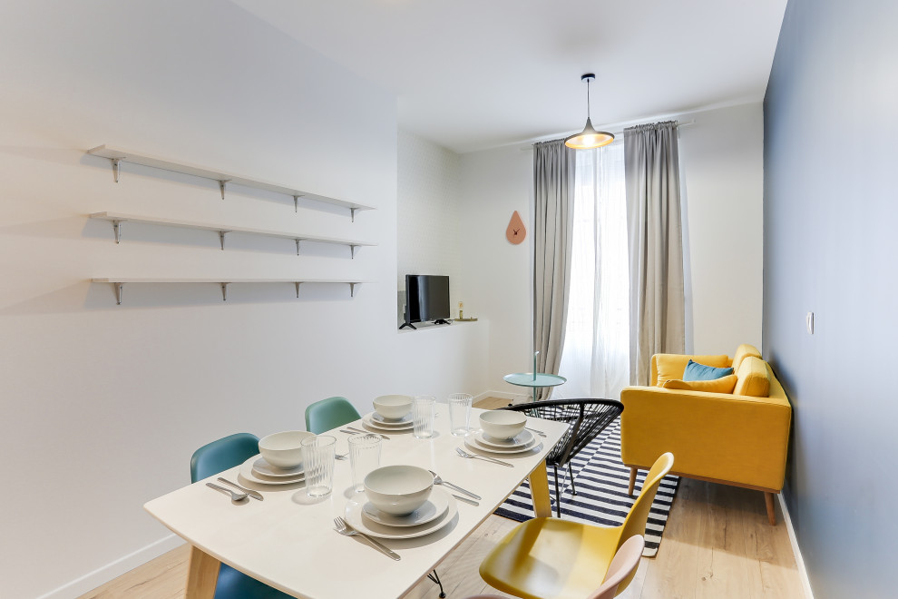 Esempio di un'ampia sala da pranzo aperta verso il soggiorno minimal con pareti blu e parquet chiaro