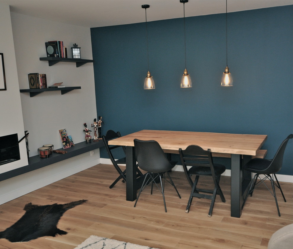 Идея дизайна: большая отдельная столовая в стиле лофт с синими стенами, светлым паркетным полом, стандартным камином, фасадом камина из камня и бежевым полом