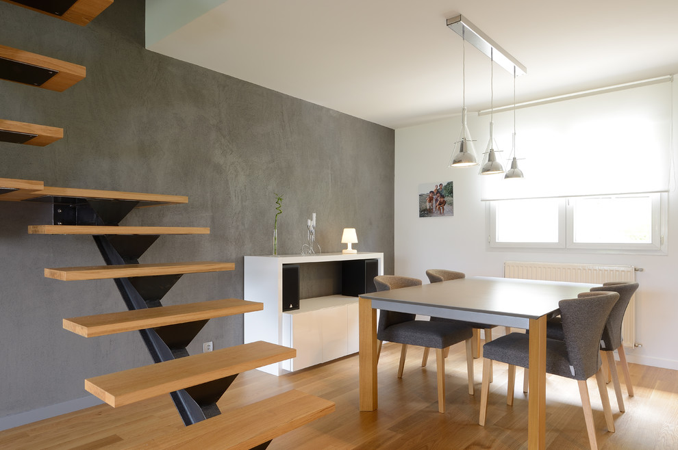 На фото: столовая среднего размера в современном стиле с серыми стенами и светлым паркетным полом без камина с