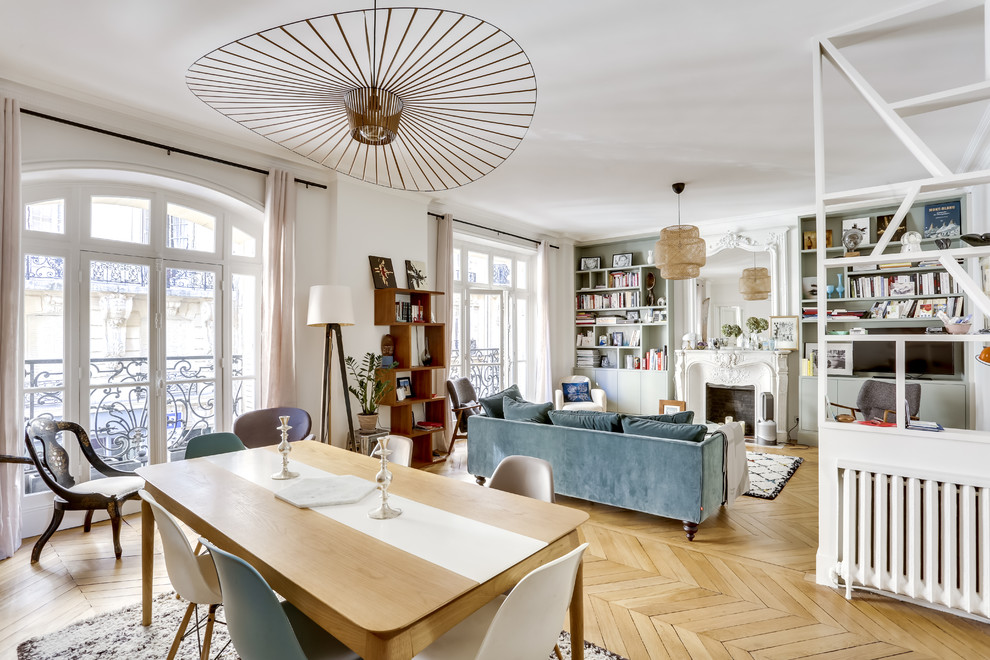 Eklektisches Esszimmer mit weißer Wandfarbe, hellem Holzboden, Kamin, Kaminumrandung aus Backstein und beigem Boden in Paris