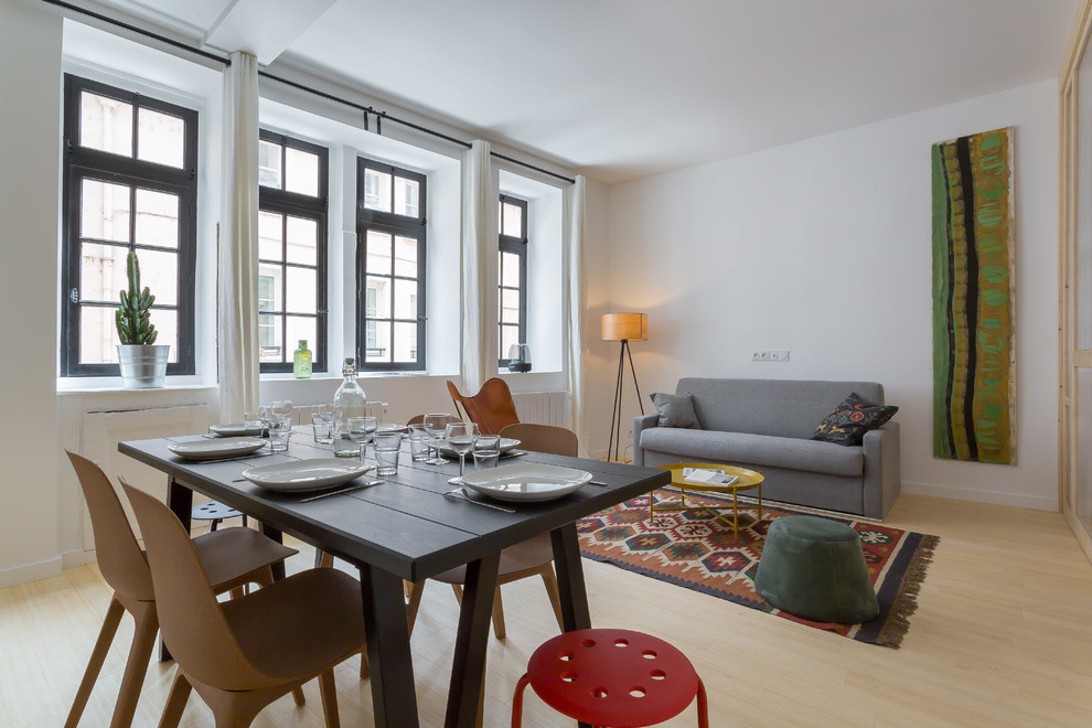 Réalisation d'une salle à manger ouverte sur le salon nordique avec un mur blanc, parquet clair et un sol beige.