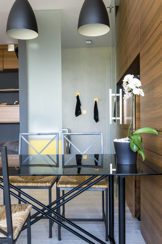 Cette image montre une salle à manger ouverte sur le salon design de taille moyenne avec un mur marron et parquet clair.