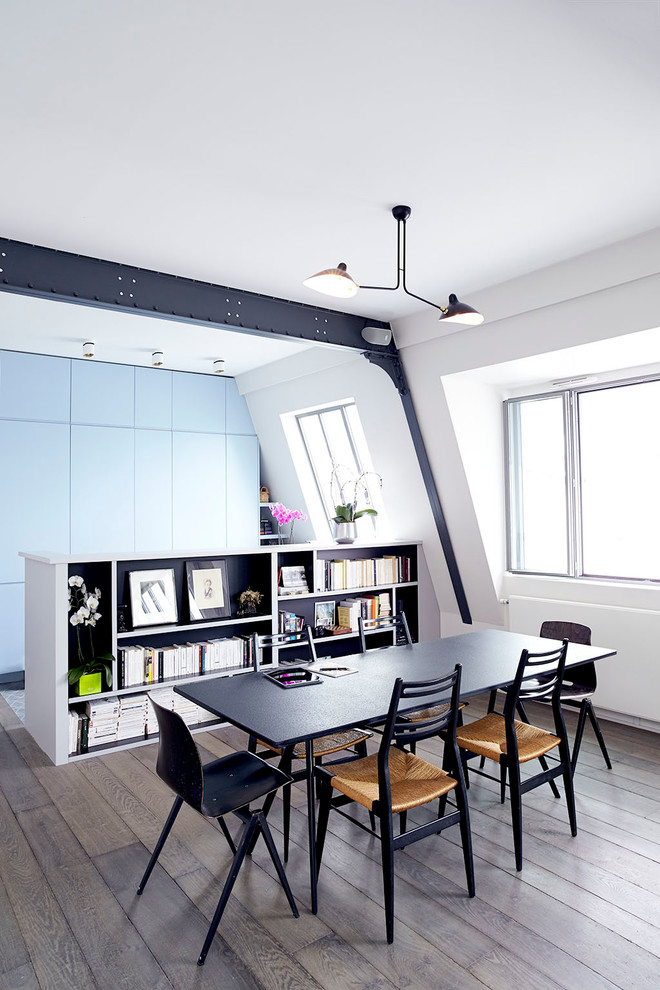 Inspiration pour une salle à manger ouverte sur le salon design de taille moyenne avec un mur blanc et un sol en bois brun.