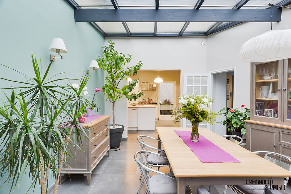 Inspiration pour une salle à manger ouverte sur le salon urbaine de taille moyenne avec un mur bleu, un sol en ardoise, aucune cheminée et un sol gris.