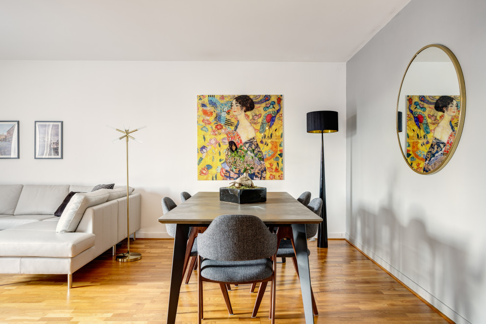 Cette image montre une salle à manger ouverte sur le salon design avec un mur gris, un sol en bois brun et un sol marron.