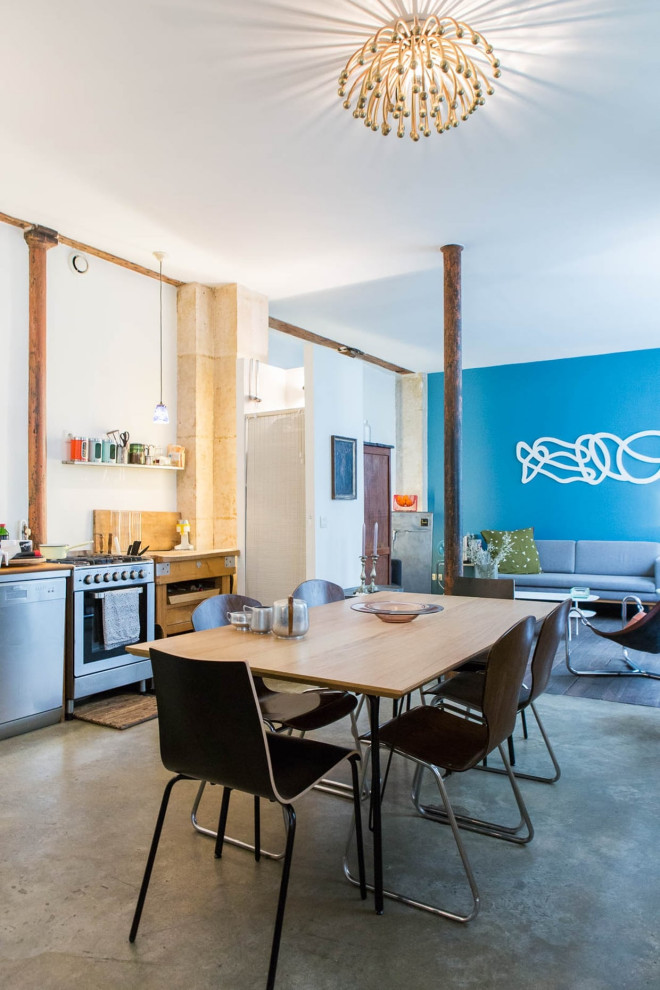 Réalisation d'une salle à manger ouverte sur le salon design de taille moyenne avec un mur bleu, sol en béton ciré et un sol gris.