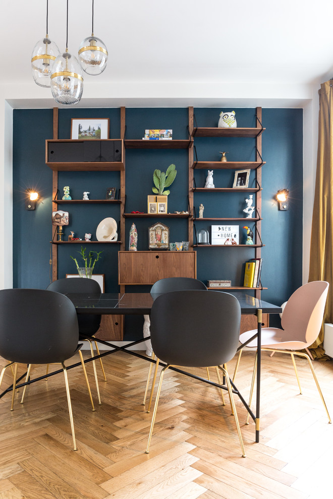 Exemple d'une salle à manger ouverte sur le salon tendance de taille moyenne avec un mur bleu, parquet clair, une cheminée standard, un manteau de cheminée en pierre et un sol beige.