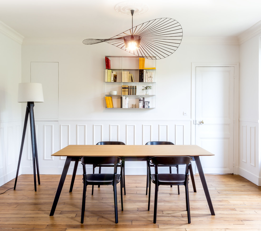 Foto di una sala da pranzo contemporanea di medie dimensioni e chiusa con pareti bianche, pavimento in legno massello medio e nessun camino