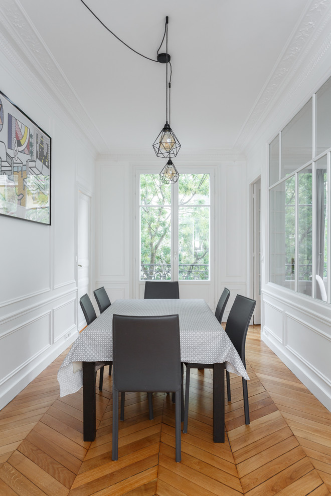 This is an example of a medium sized scandi enclosed dining room in Other with white walls, medium hardwood flooring, no fireplace and brown floors.