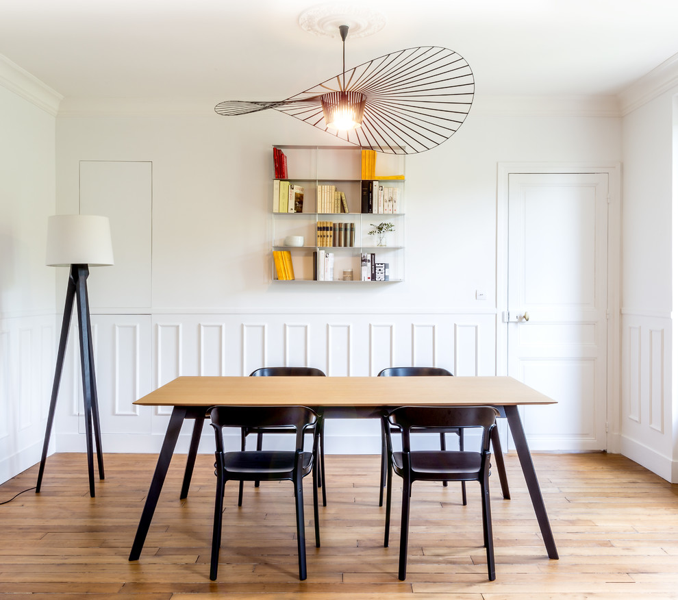Foto de comedor minimalista grande sin chimenea con paredes blancas y suelo de madera clara