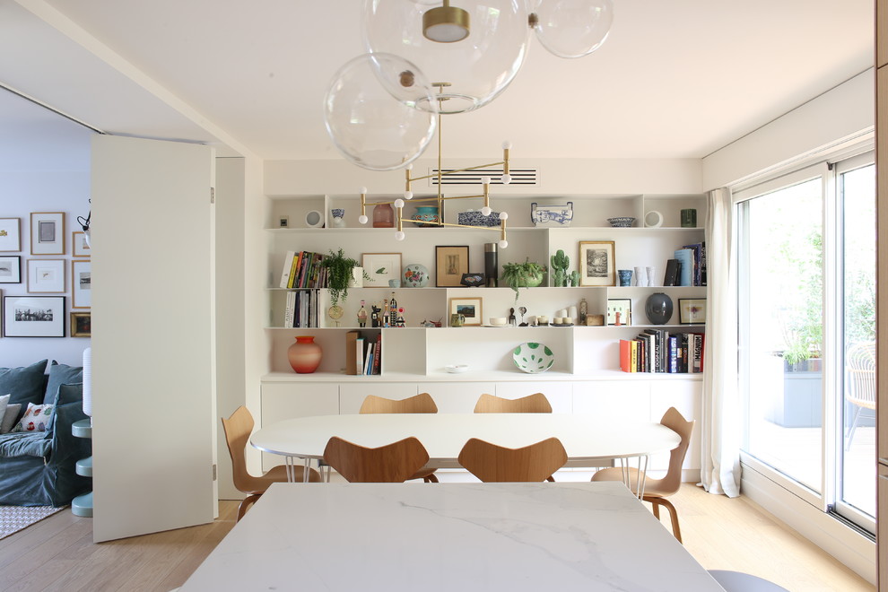 Cette photo montre une salle à manger ouverte sur le salon tendance de taille moyenne avec un mur blanc, parquet clair et un sol beige.