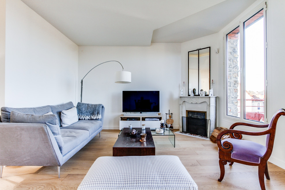 パリにある高級な広いコンテンポラリースタイルのおしゃれなLDK (白い壁、淡色無垢フローリング、コーナー設置型暖炉、石材の暖炉まわり、ベージュの床) の写真