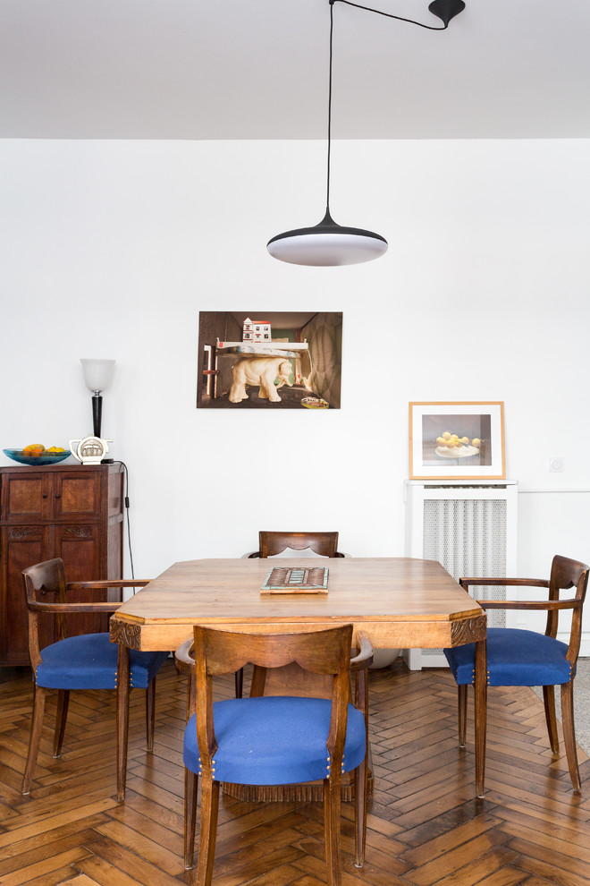 Immagine di una sala da pranzo aperta verso il soggiorno industriale di medie dimensioni con pareti bianche, pavimento in legno massello medio, nessun camino e pavimento marrone