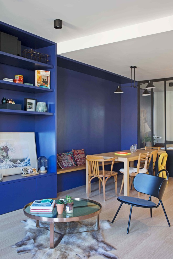 Diseño de comedor contemporáneo con paredes azules y suelo de madera clara
