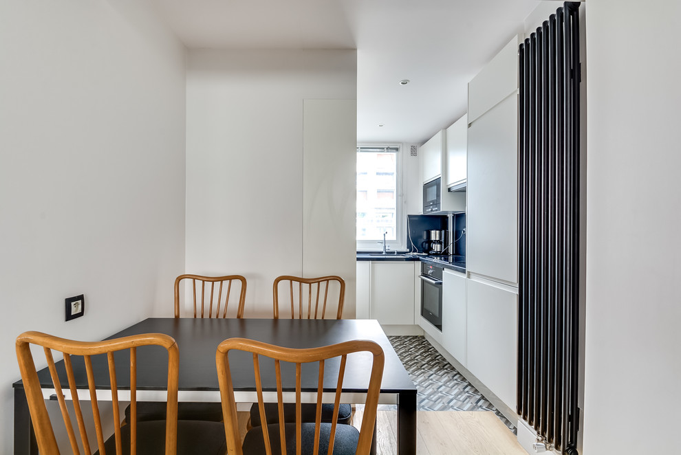 Стильный дизайн: маленькая гостиная-столовая в стиле ретро с белыми стенами, светлым паркетным полом и коричневым полом без камина для на участке и в саду - последний тренд