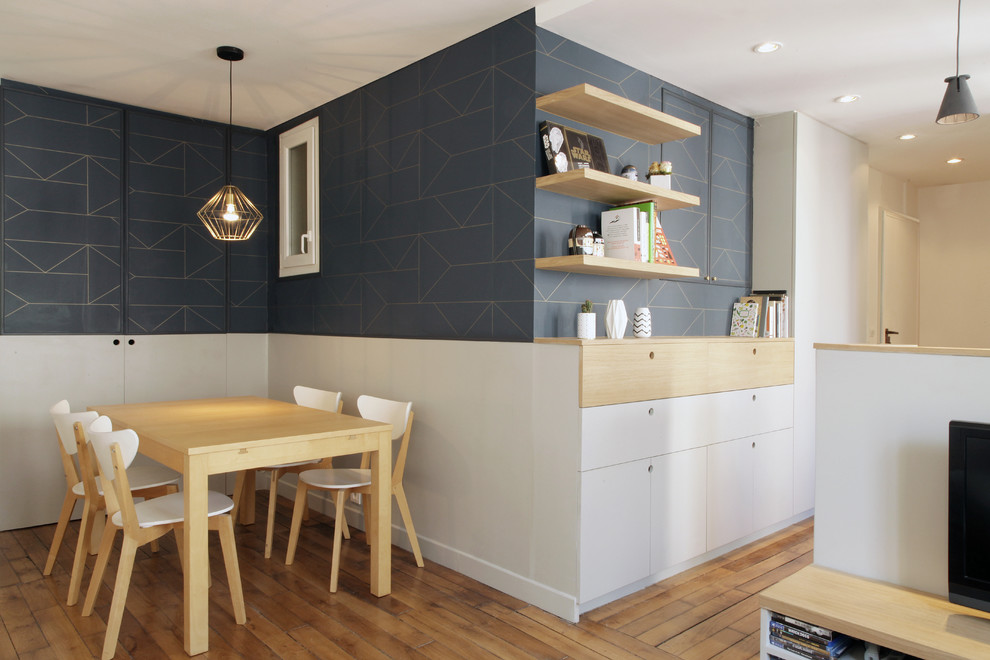 Immagine di una piccola sala da pranzo aperta verso il soggiorno nordica con pareti blu, parquet chiaro e nessun camino