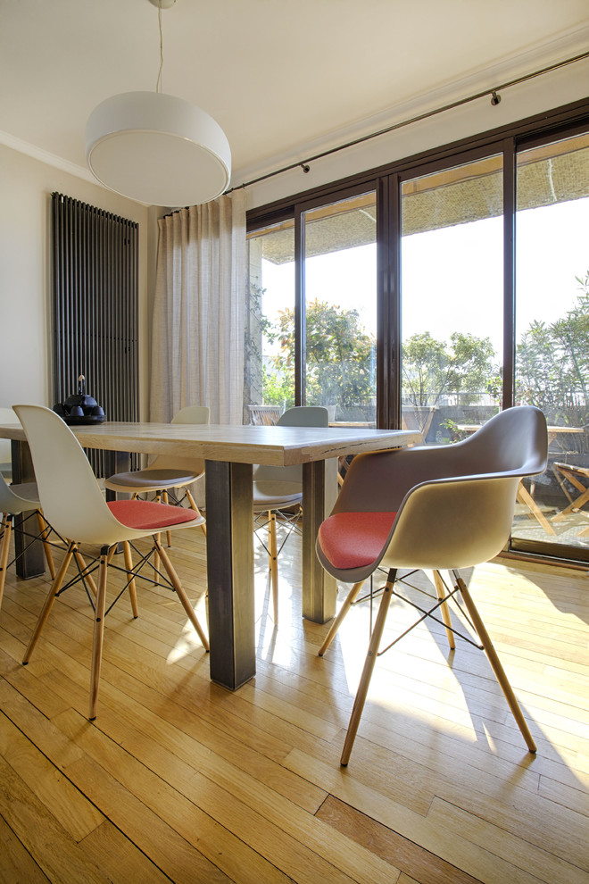 Idée de décoration pour une salle à manger ouverte sur la cuisine minimaliste avec un mur gris et parquet clair.