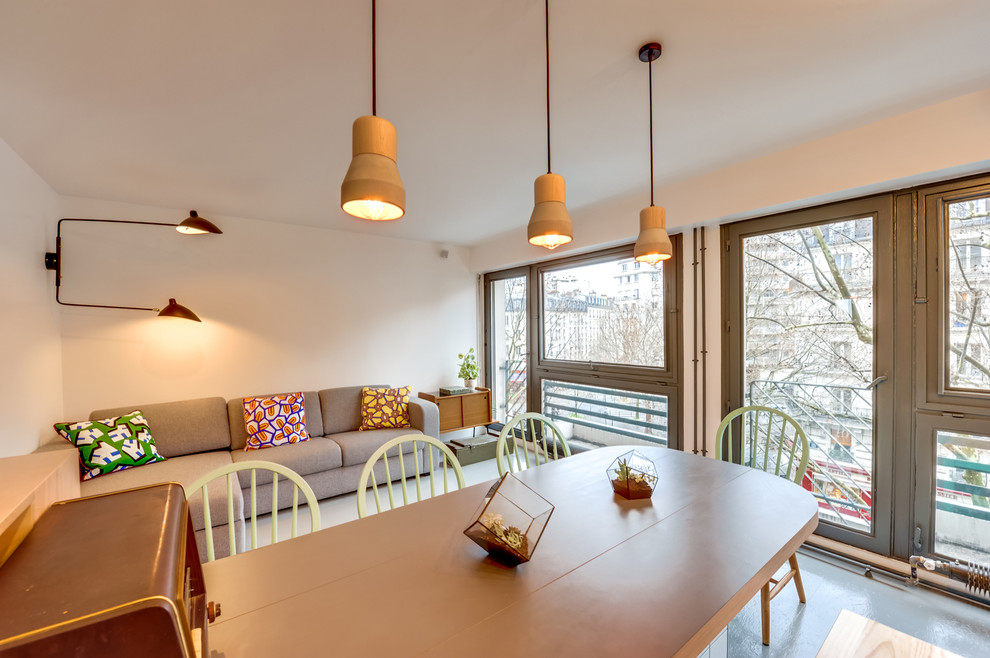 Cette photo montre une salle à manger ouverte sur le salon scandinave de taille moyenne avec un mur blanc, aucune cheminée et éclairage.