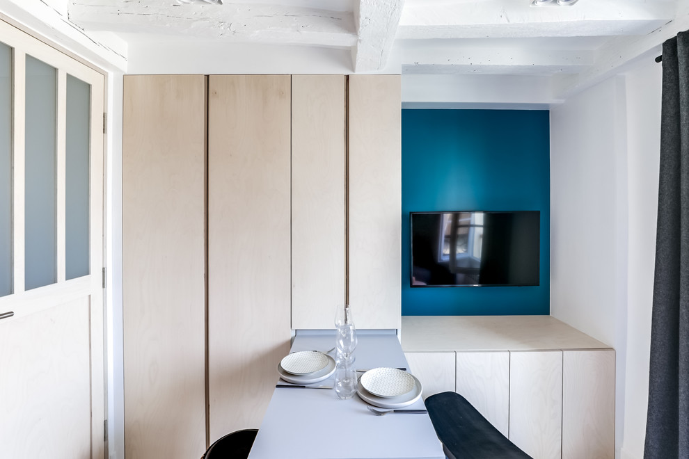 Inspiration pour une petite salle à manger ouverte sur le salon design avec un mur bleu, parquet peint, aucune cheminée et un sol blanc.