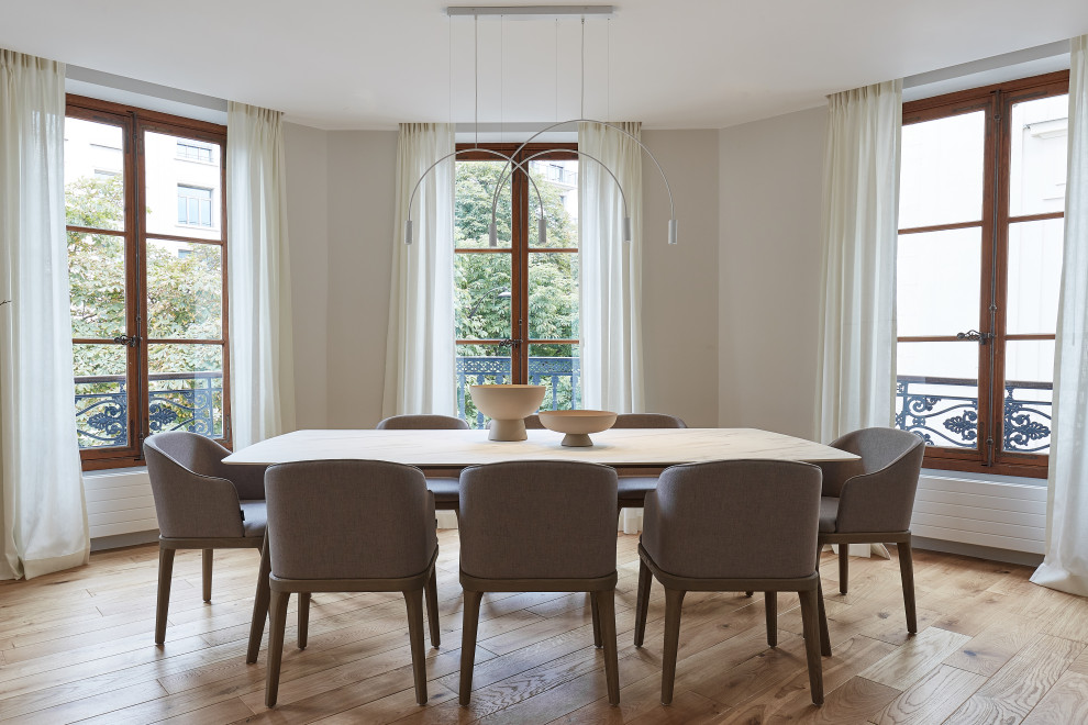 Esempio di una sala da pranzo minimal con parquet chiaro, pareti beige e pavimento beige