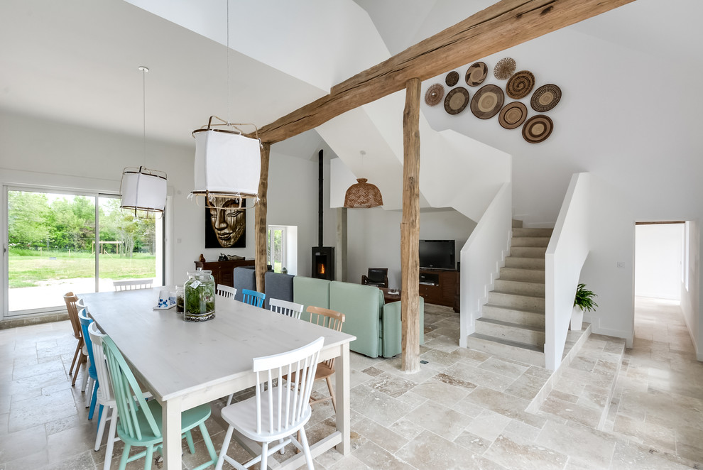 Idee per una grande sala da pranzo scandinava con pareti bianche, stufa a legna, pavimento beige e pavimento in cemento