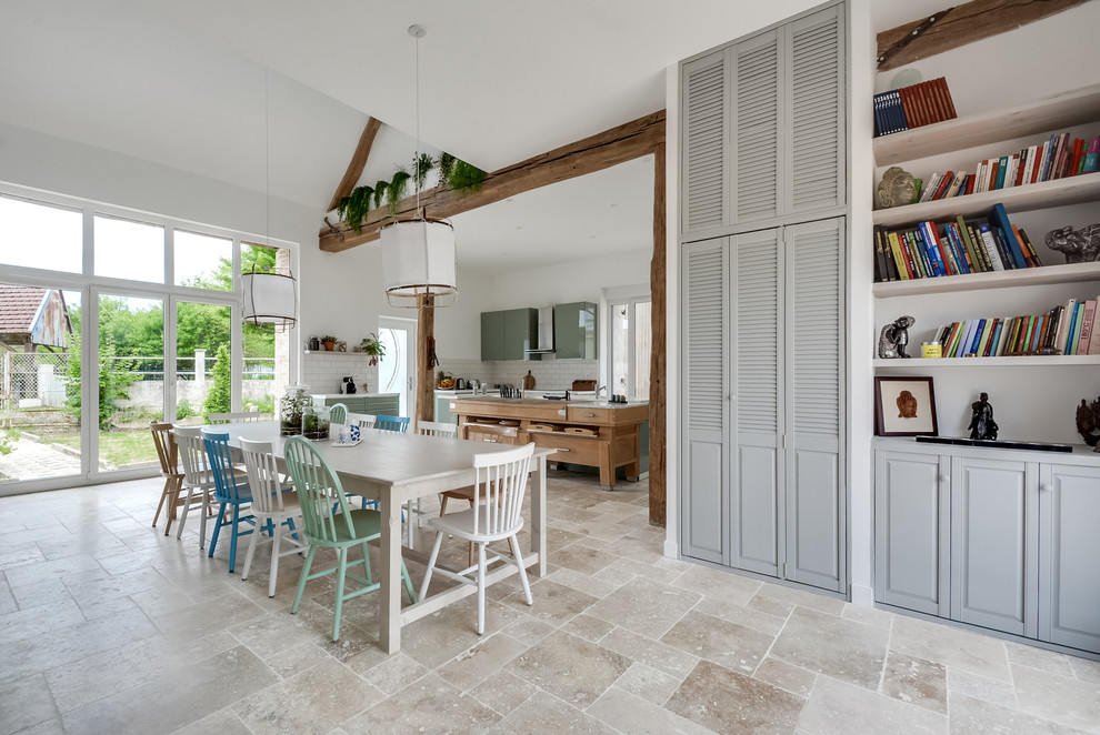Ispirazione per una grande sala da pranzo aperta verso il soggiorno eclettica con pareti bianche, pavimento in marmo, stufa a legna e pavimento beige