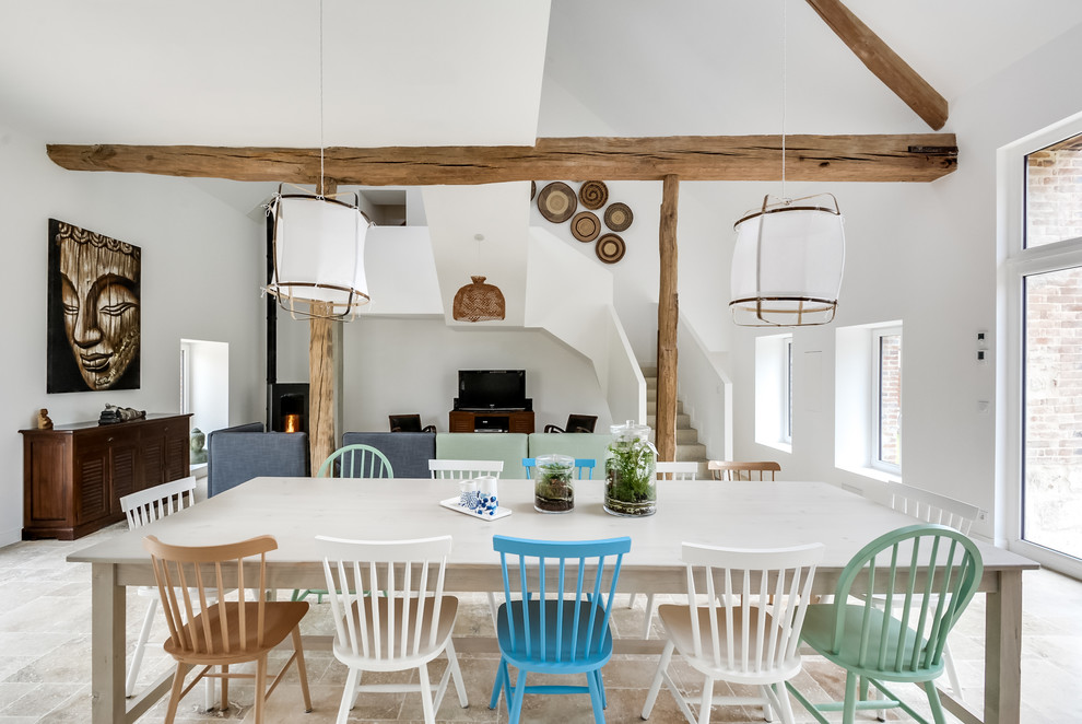 Aménagement d'une grande salle à manger ouverte sur le salon éclectique avec un mur blanc, un sol en marbre, un poêle à bois et un sol beige.