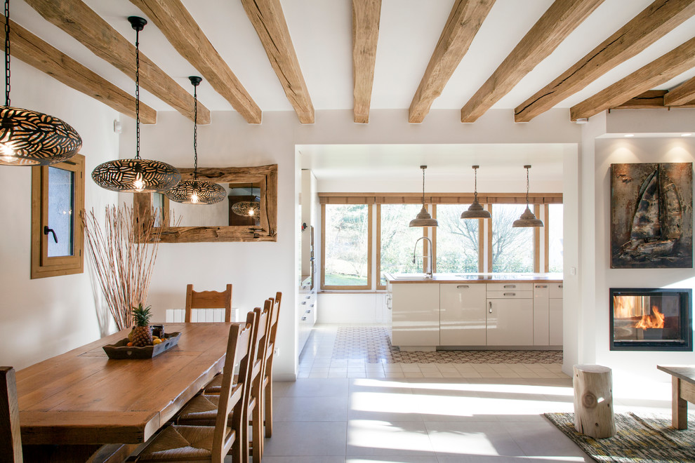 Diseño de comedor de estilo de casa de campo de tamaño medio abierto con chimenea de doble cara y paredes blancas