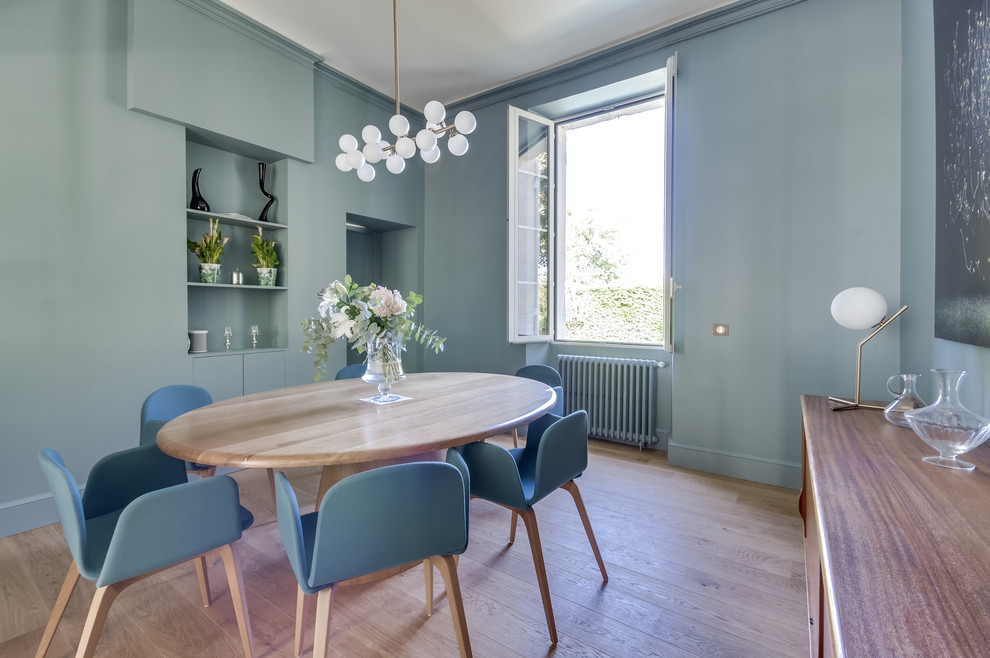 Cette photo montre une salle à manger tendance avec un mur bleu, parquet clair et un sol beige.