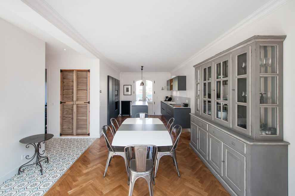 Esempio di una sala da pranzo aperta verso la cucina bohémian con pareti bianche, pavimento in legno massello medio e pavimento marrone