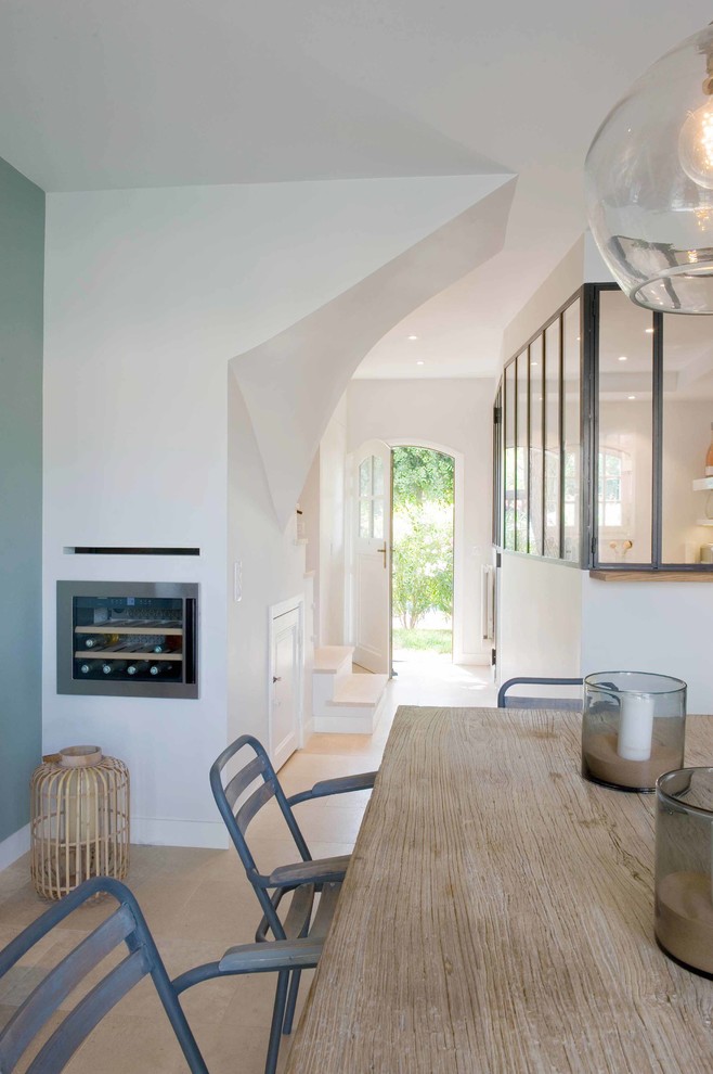 Immagine di una sala da pranzo aperta verso il soggiorno design di medie dimensioni con pareti bianche, pavimento in terracotta e pavimento beige