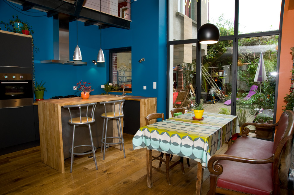 Esempio di una piccola sala da pranzo aperta verso il soggiorno bohémian con parquet chiaro e pareti blu