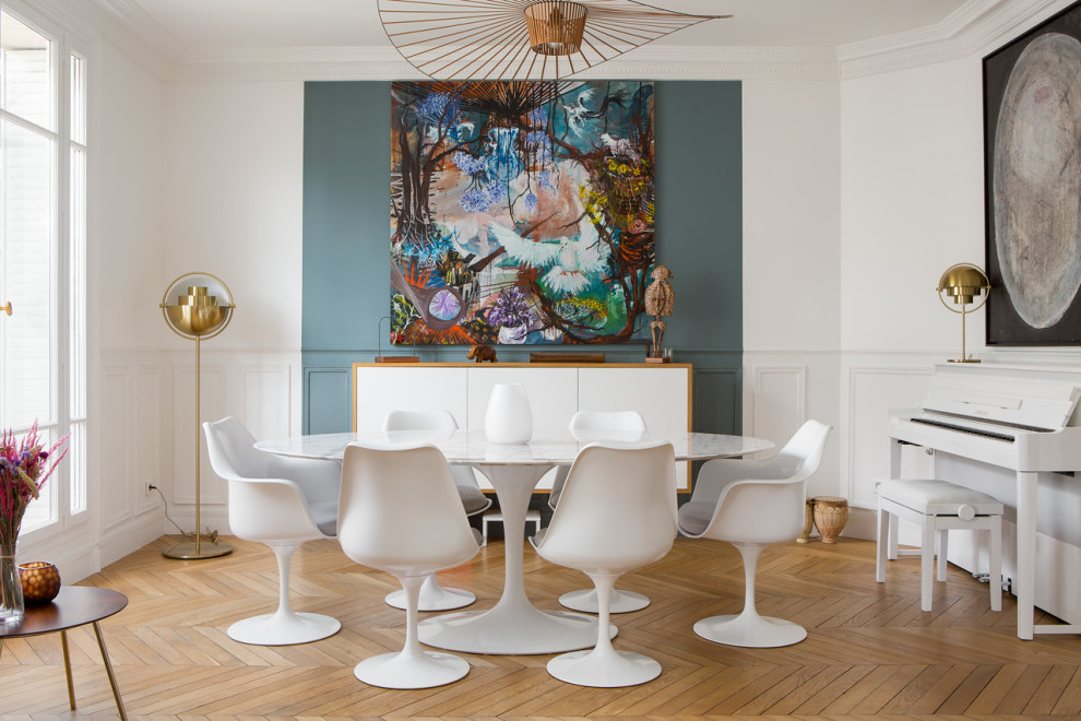 Foto di una sala da pranzo minimal con pareti bianche, pavimento in legno massello medio, pavimento marrone e boiserie