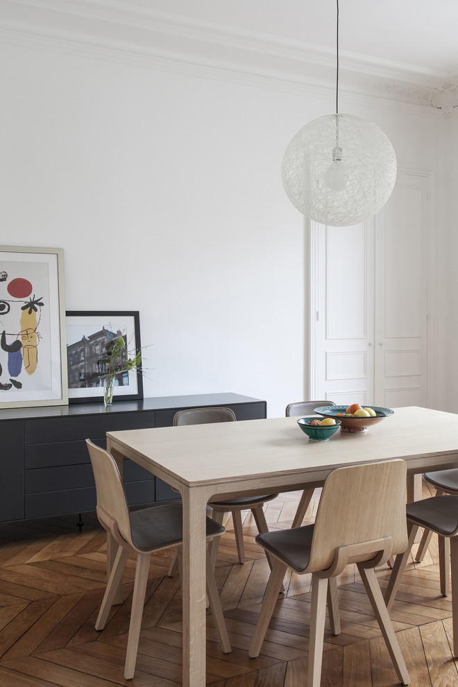 Aménagement d'une salle à manger contemporaine avec un mur blanc, un sol en bois brun et un sol marron.