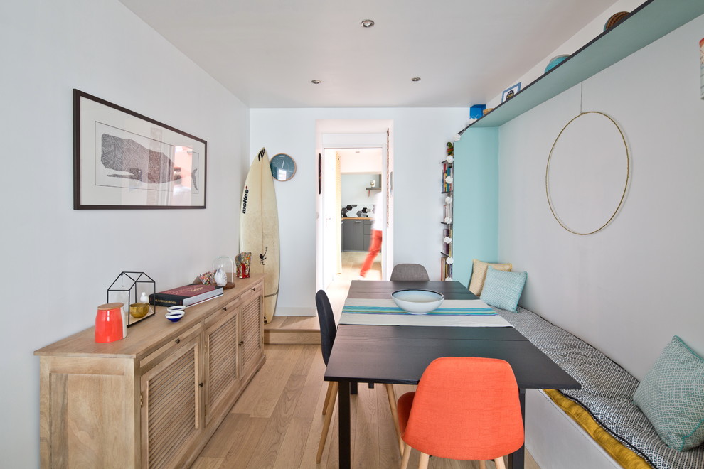 Immagine di una piccola sala da pranzo stile marinaro chiusa con pareti bianche, pavimento in legno massello medio e pavimento beige
