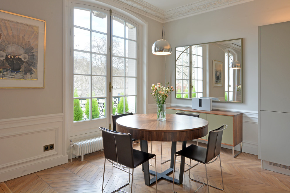 Exemple d'une salle à manger ouverte sur le salon tendance de taille moyenne avec un mur blanc, parquet clair, aucune cheminée et un sol marron.