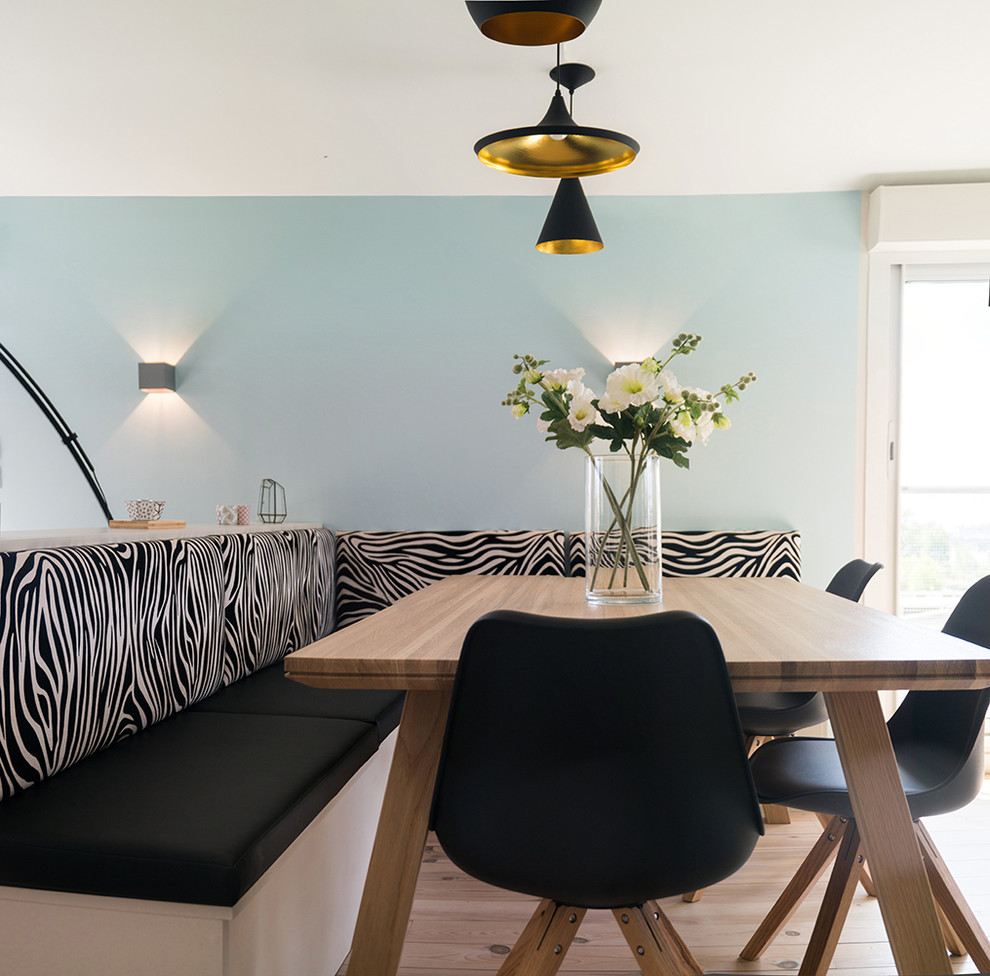 Ejemplo de comedor contemporáneo de tamaño medio abierto con paredes azules, suelo de madera clara, estufa de leña, marco de chimenea de metal y suelo beige