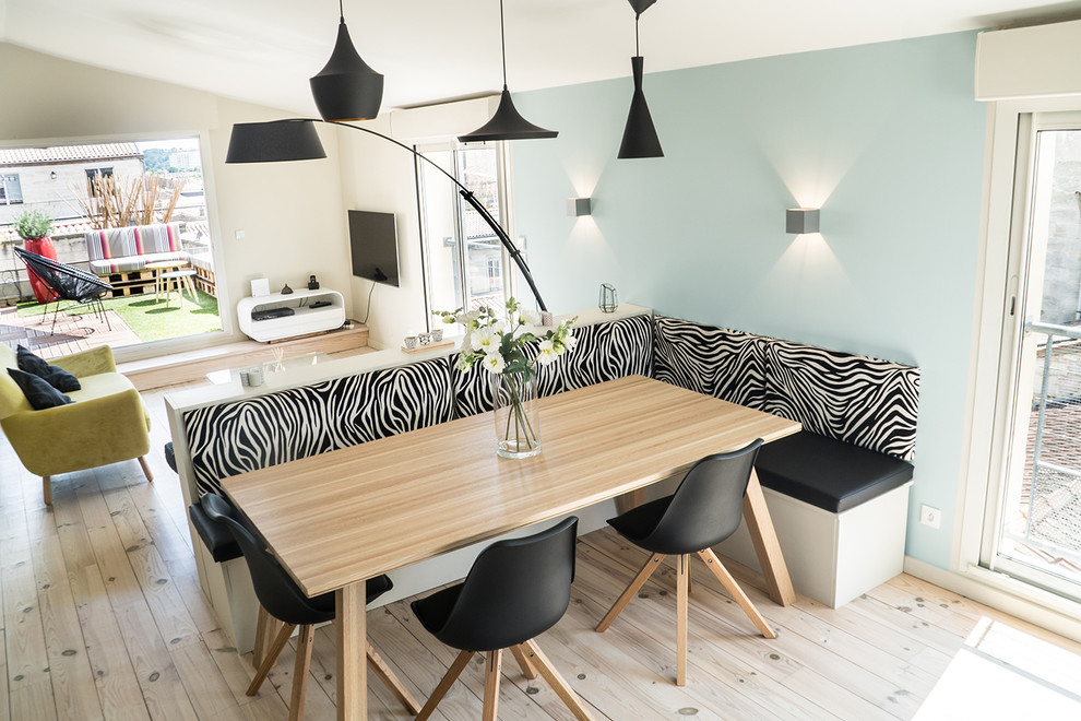 Diseño de comedor contemporáneo de tamaño medio abierto con paredes azules, suelo de madera clara, estufa de leña, marco de chimenea de metal y suelo beige