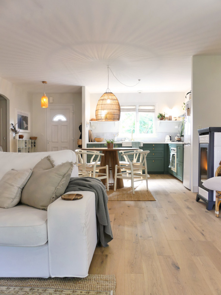Immagine di una sala da pranzo aperta verso il soggiorno stile marinaro di medie dimensioni con parquet chiaro, pareti bianche e pavimento marrone