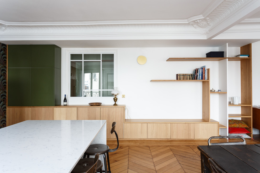 Exemple d'une salle à manger ouverte sur la cuisine moderne de taille moyenne avec un mur vert, un sol en bois brun, aucune cheminée et un sol marron.