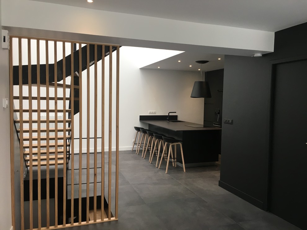 Mittelgroße Moderne Wohnküche mit schwarzer Wandfarbe, Keramikboden und schwarzem Boden in Paris