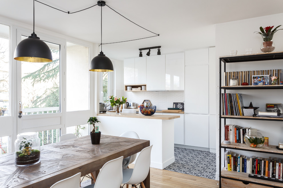 Immagine di una sala da pranzo aperta verso il soggiorno minimalista di medie dimensioni con pareti bianche, parquet chiaro, pavimento beige e nessun camino