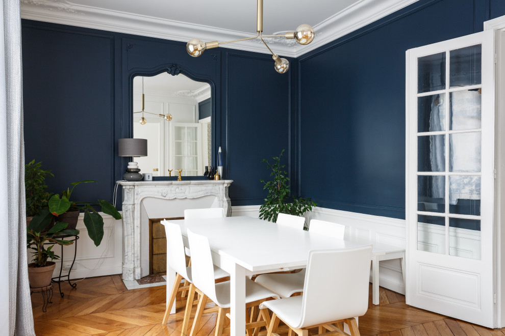 Aménagement d'une salle à manger classique avec un mur bleu, un sol en bois brun, une cheminée standard et un sol marron.
