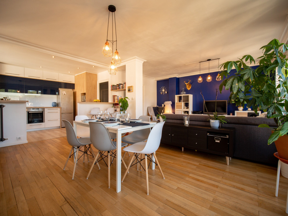 Exemple d'une grande salle à manger ouverte sur le salon tendance avec un mur bleu, parquet clair, aucune cheminée et un sol beige.