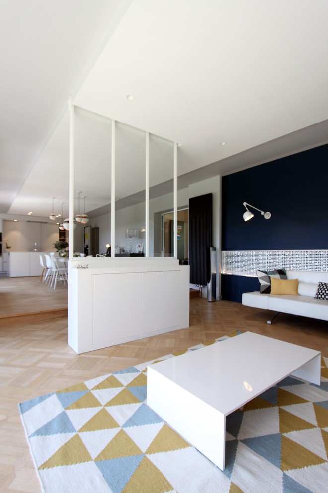 Ispirazione per una grande sala da pranzo aperta verso la cucina design con pareti blu, parquet chiaro e camino classico