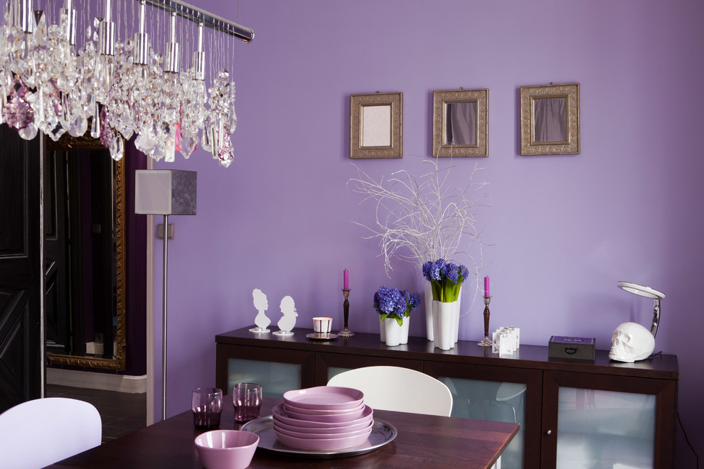 Imagen de comedor actual con paredes púrpuras, suelo de madera en tonos medios y suelo marrón