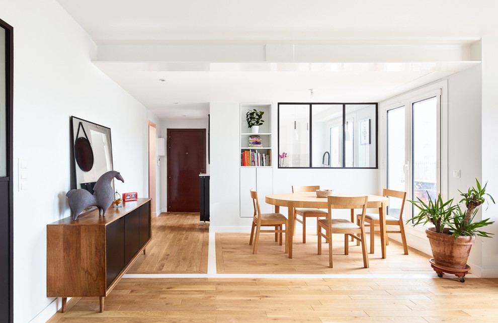 Aménagement d'une grande salle à manger ouverte sur le salon scandinave avec un mur blanc, parquet clair et un sol beige.